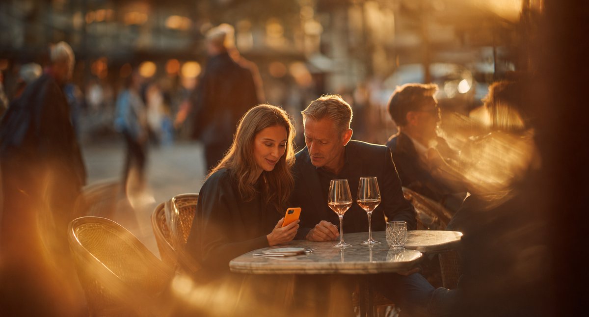 A couple sitting at a café receiving a Halo water leak alert on a phone
